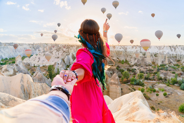 Boho girl traveler vacations beautiful destination in Goreme, Turkey. Follow me to fabulous Kapadokya with flying air balloons at sunrise, Anatolia