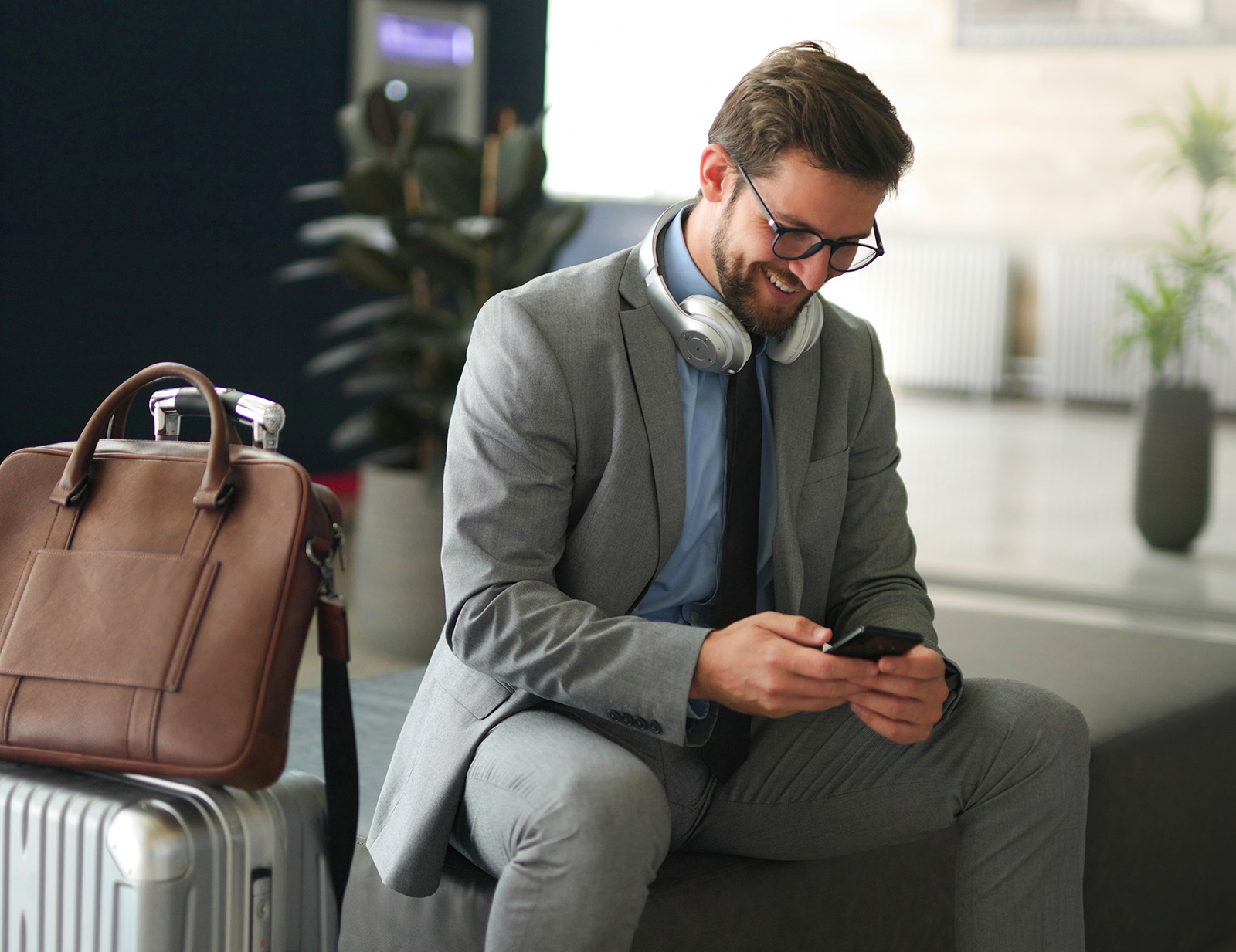 Businessman using phone while waiting for a train at train station